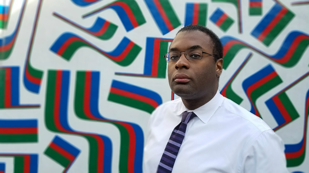 WRB employee Bilal Uqdah poses for a photograph in front of a mural in Center City, Philadelphia