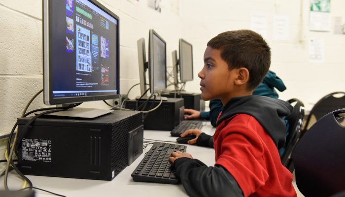 A boy staring at a computer