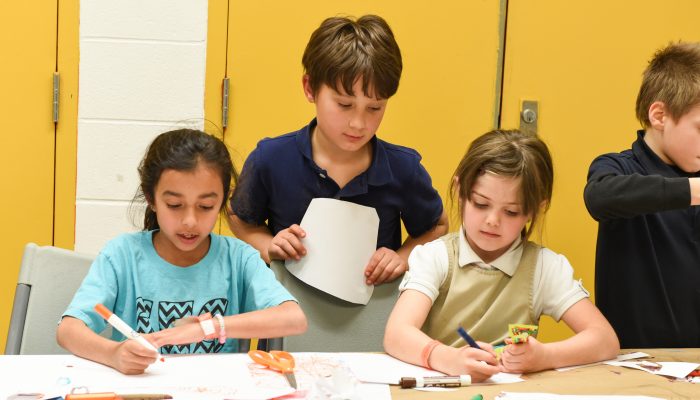 Three children do crafts and art