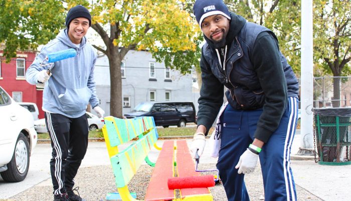 two men painting a park bench