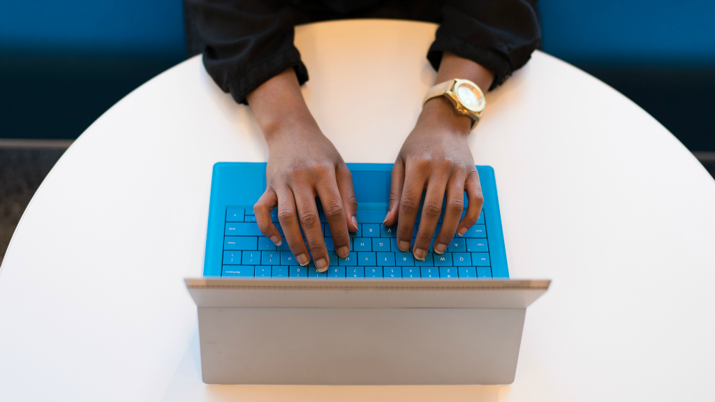 Overhead view of a woman typing on a laptop computer
