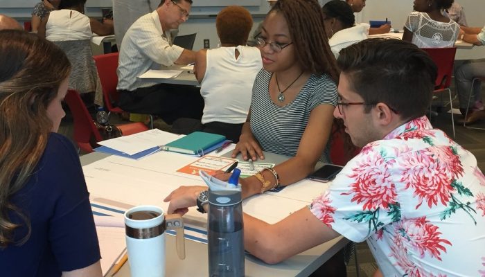 A group of people at a table working on an activity together.