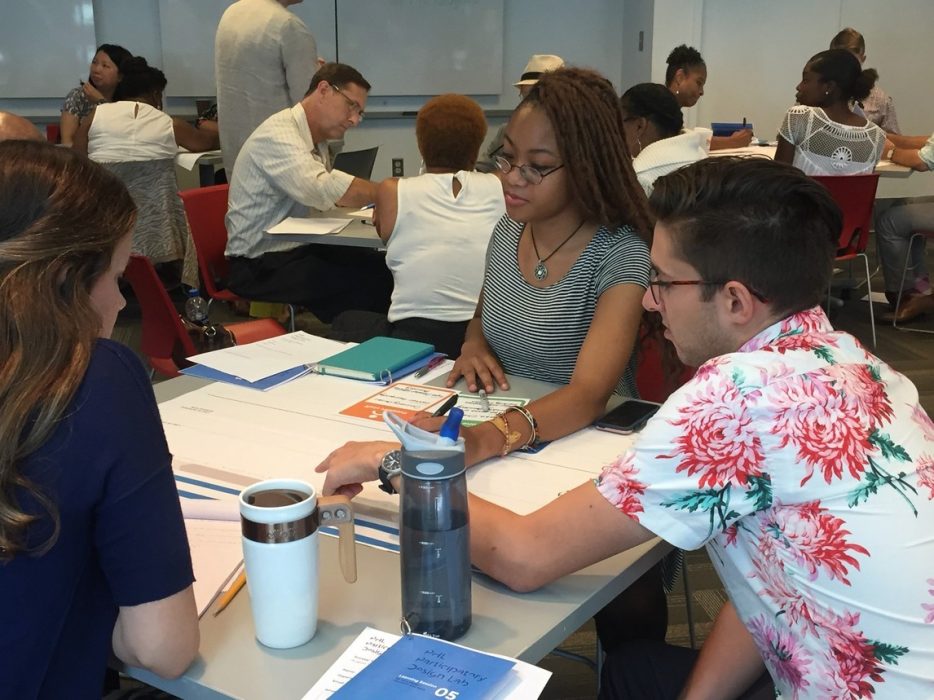 A group of people at a table working on an activity together.