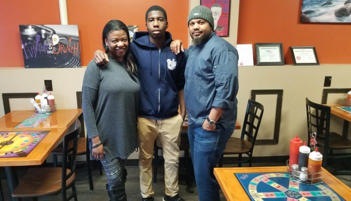 Regina Young, Tilden Middle School Community School coordinator, Donovan Rivers, Bartram High School senior, and Tarik Rant Rhythm and Brunch restaurant manager smile together.