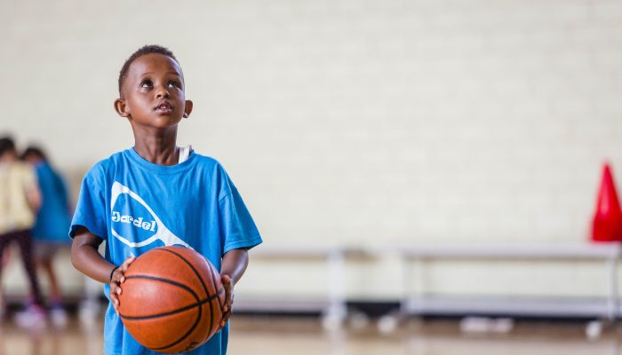 A boy holding a basketball, looking up