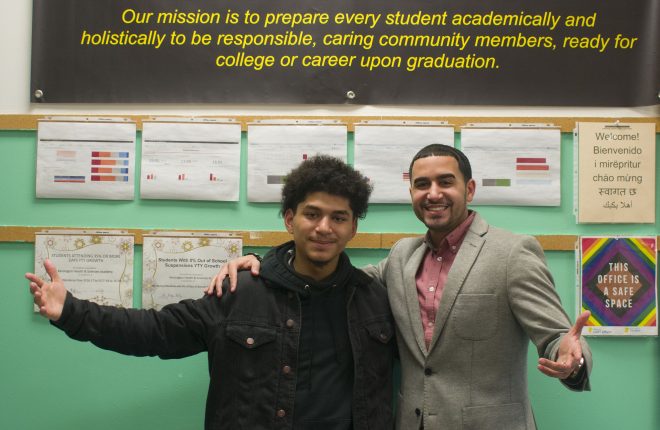 Bryan Lopez-Roman, Kensington Health Sciences Academy (KHSA) senior and Antonio Romero, Kensington Health Sciences Academy (KHSA) coordinator smile together with their arms out.