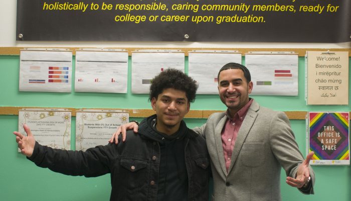 Bryan Lopez-Roman, Kensington Health Sciences Academy (KHSA) senior and Antonio Romero, Kensington Health Sciences Academy (KHSA) coordinator smile together with their arms out.