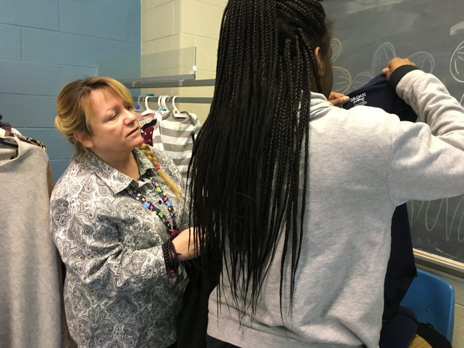 Kim Britt, George Washington High School climate support staff, helps a parent shop for clothing