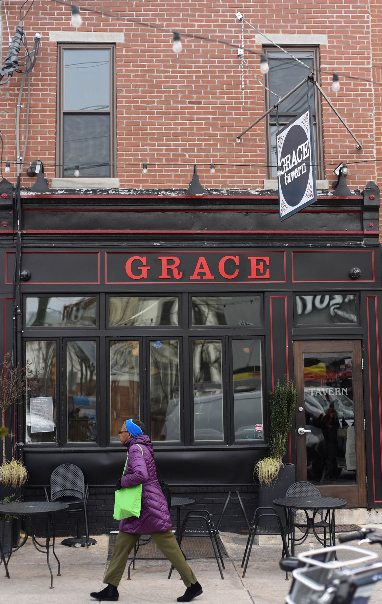 A person walks by Grace Tavern.