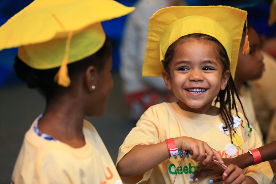 Two pre-K kids wearing yellow graduation caps