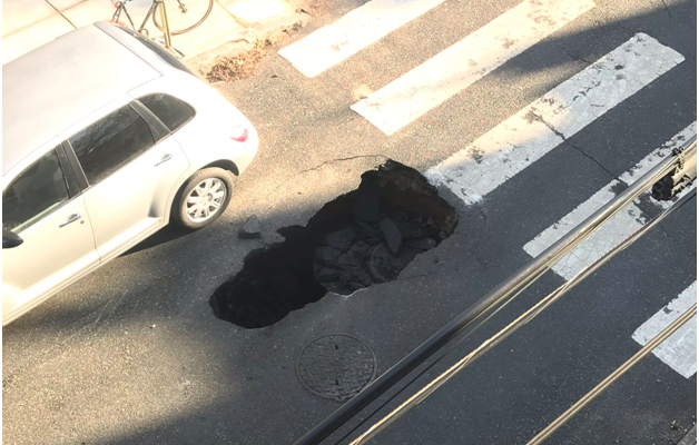 street cave in that is about the length of half a car 