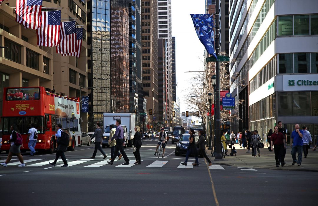 people walking across a crosswalk in center city