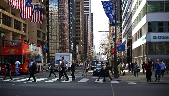 people walking across a crosswalk in center city