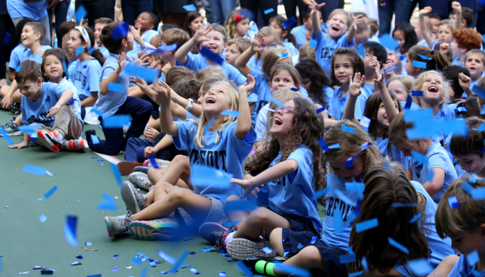 Elementary school students attend an event in the school playground