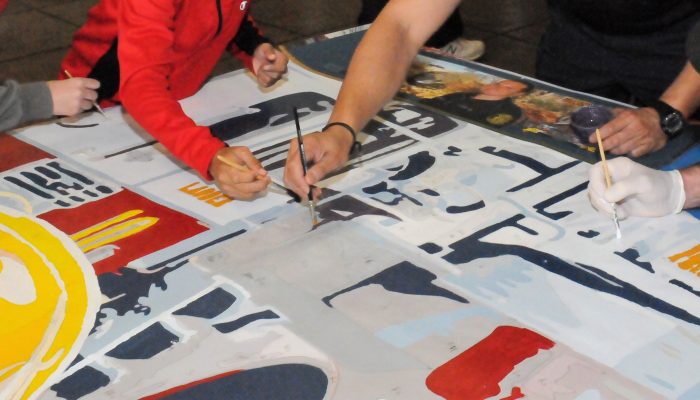 close up of hands painting a mural