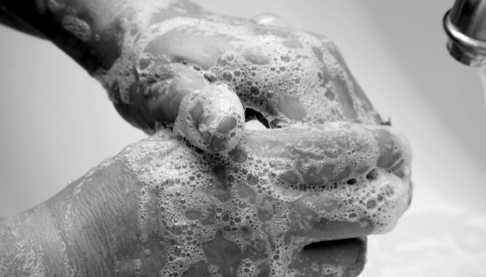 Una persona lavandoze las manos con mucho jabon