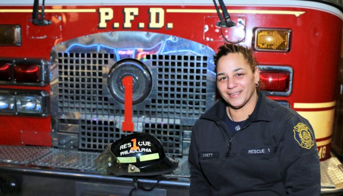female firefighter in front of fire engine