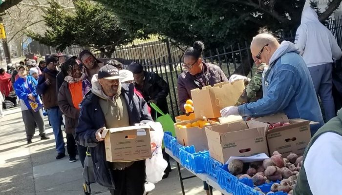 Community members line up around the block for a Fresh For All food distribution at Dobbins CTE High School.