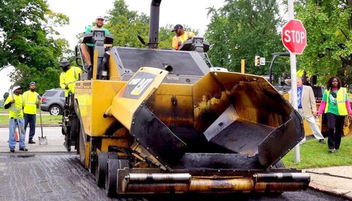 Workers operating a paving machine