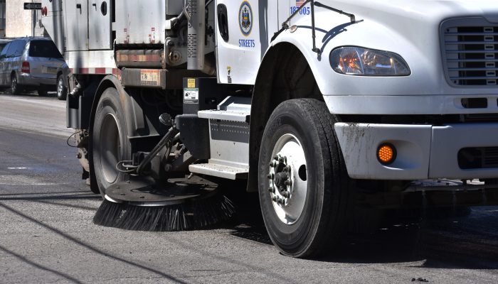 primer plano de una escoba giratoria en un camión de barrido de calles