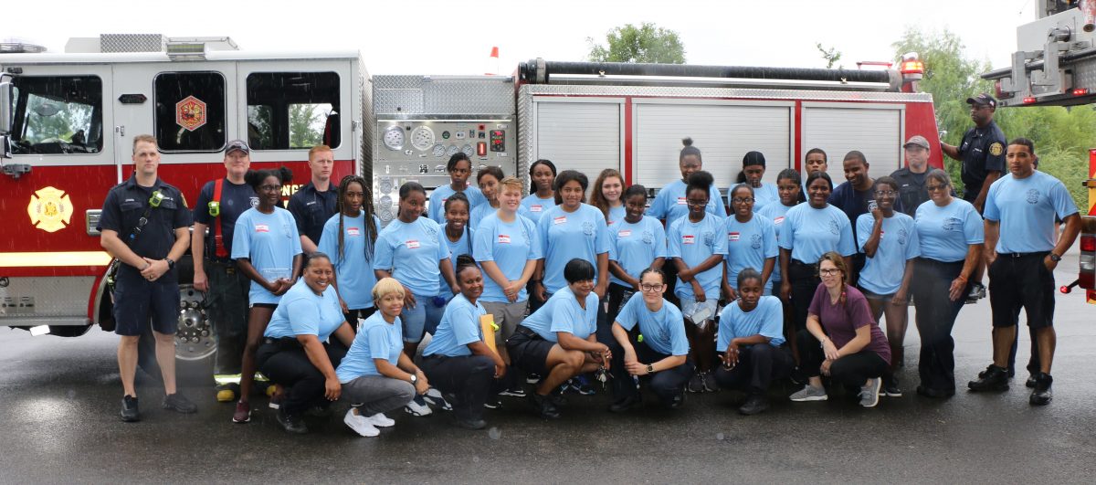 Campers posing in front of a fire engine