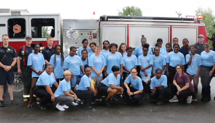 Campers posing in front of a fire engine