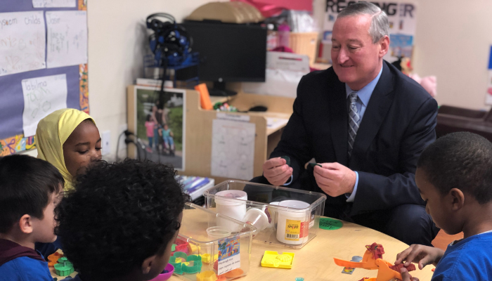Mayor Kenney and students sitting together at a table learning with playdoh.