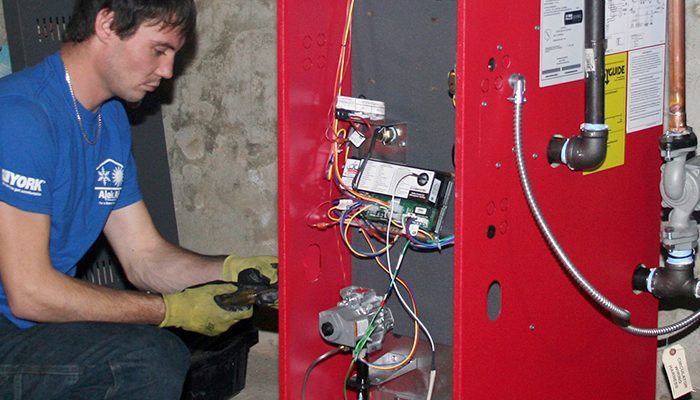 A man workers on a heating unit.