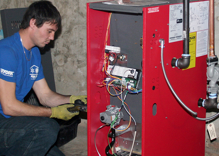 A man workers on a heating unit.