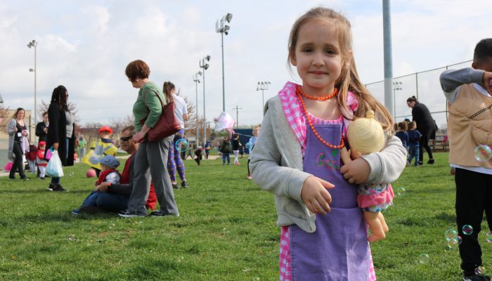 PHLpreK student Gemma standing and smiling at the 2019 Week of the Young Child parade.