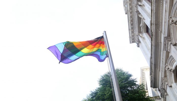 More Color, More Pride LGBTQ Pride flag on flag pole.
