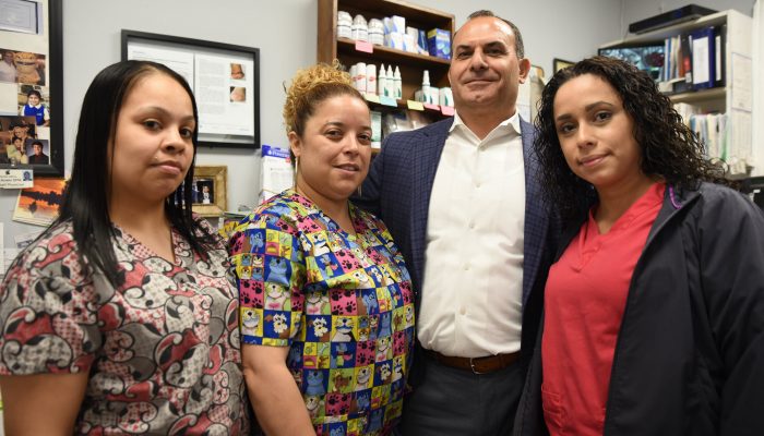 A podiatrist, Dr. Anaim, stands with three of his staff members in his North Philadelphia practice.
