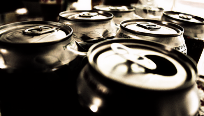 A very close view of the tops of a six-pack of soda cans.