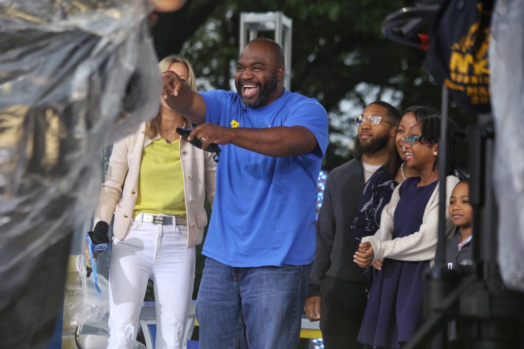 Charles Reyes Community Schools coordinator smiling and pointing at the Good Morning America crowd, suprised