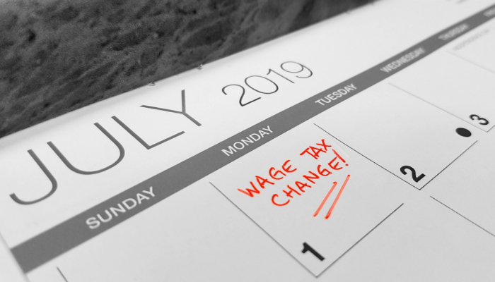 The words "Wage Tax Change" are handwritten on a calendar on the date July 1, 2019