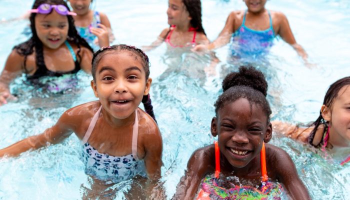 A group of children smile while swimming in a Philadelphia public pool