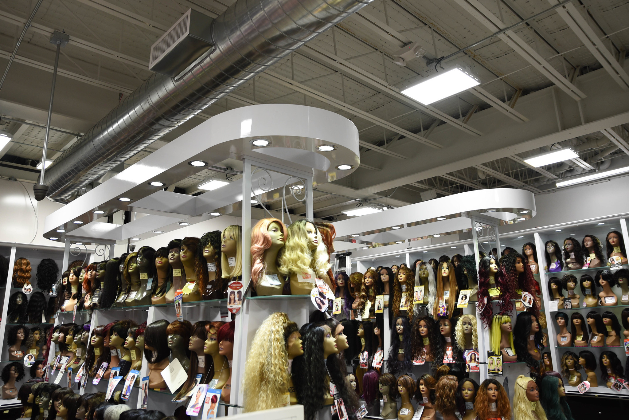 The interior of Tops Beauty, featuring new shelving that displays the store's selection of wigs. 