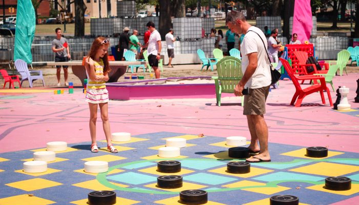 Family plays checkers at The Oval+.