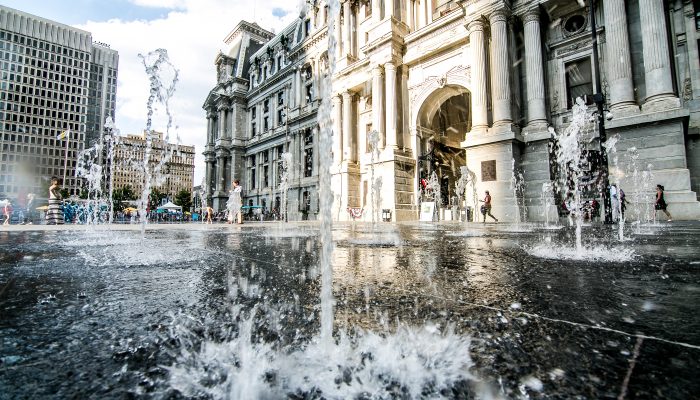 Fountains shoot water up from the ground in Dilworth Park next to City Hall during a hot day in summer 2019.