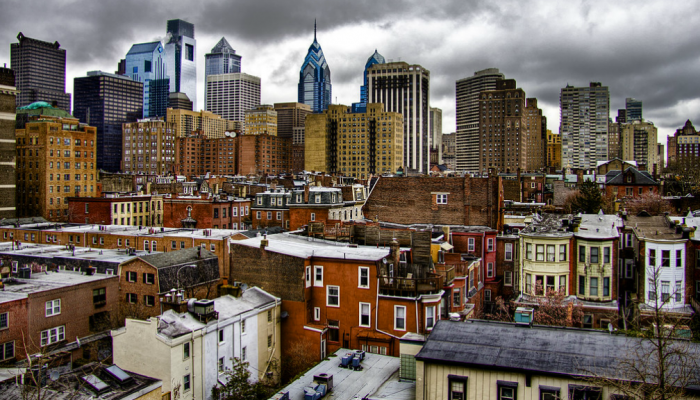 Bird's eye view of South Philadelphia houses with city skyscrapers in the background.