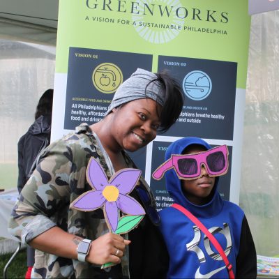 Mother and son pose with flower and sunglasses prop during the 2019 Science Festival Carnival