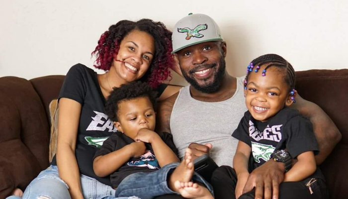 Tamisha Drummond, David Drummond and their children PHLpreK students Savannah and Malcolm smile wearing Philadelphia Eagles hats and t-shirts.