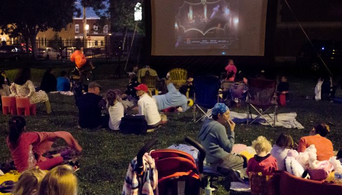 People on the lawn, watching a movie