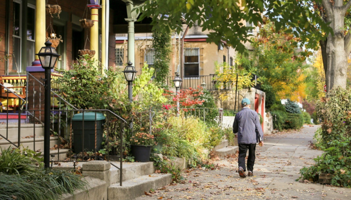 A senior walks along a tree-lined street in West Philadelphia