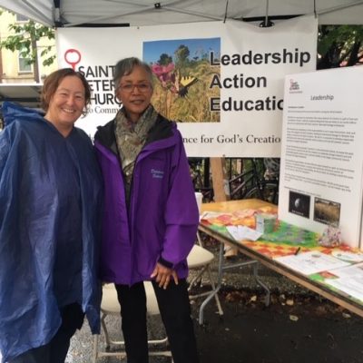 two members of St. Peter's church stand near informational table at 2018 Greenfest Philly