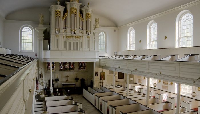 Interior of St. Peter's Church, large room with white walls and massive organ