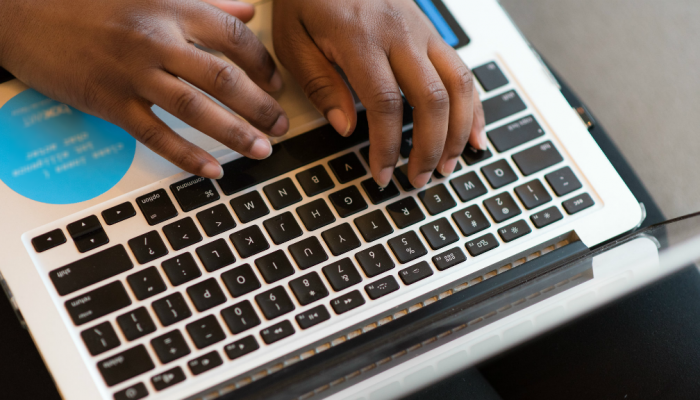A woman types at her laptop computer.