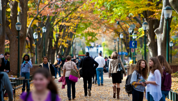 University students and faculty stroll through Locust Walk in West Philadelphia on a fall day