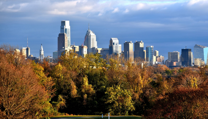 The Philadelphia skyline in the background, with Fairmount Park trees in the foreground