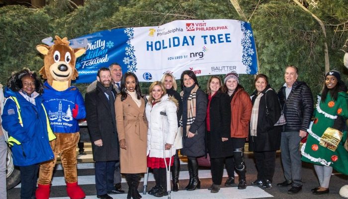 City officials stand in front of the trailer carrying the Holiday Tree in front of City Hall.